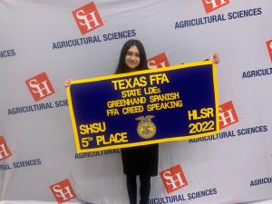 Jimena Garnica shows off her Texas FFA 5th Place Winner's Banner